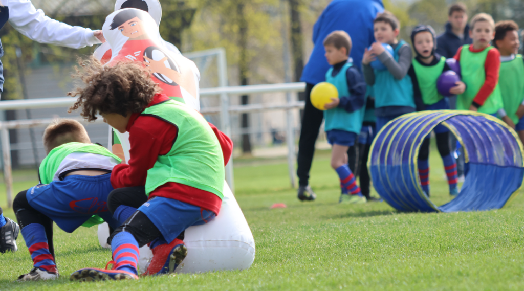 Un jeune rugbyman qui fait un plaquage sur mannequin de contact
