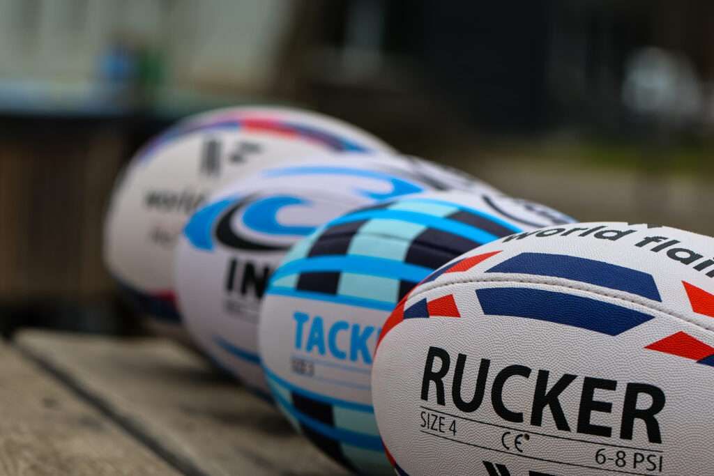 4 rugby balls, 1 in the foreground