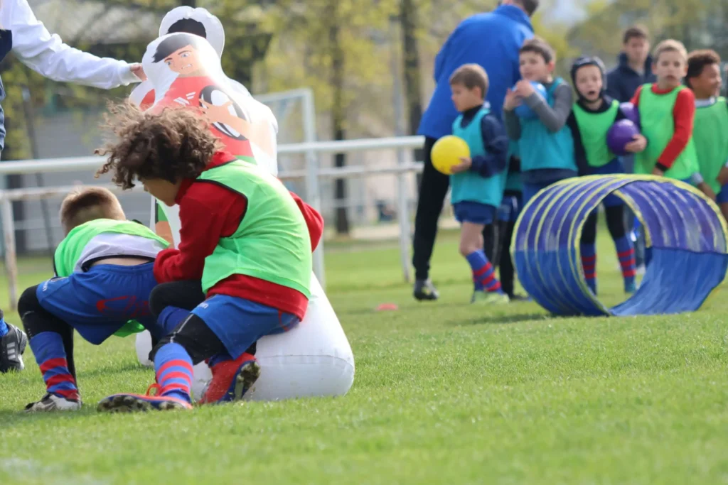 Jeune joueur de rugby entrain de faire un plaquage de rugby sur un mannequin de contact